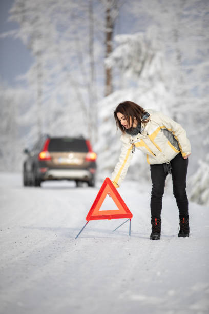 mulher bonita, jovem montando um triângulo de aviso depois que seu carro quebrou - car winter road reflector snow - fotografias e filmes do acervo