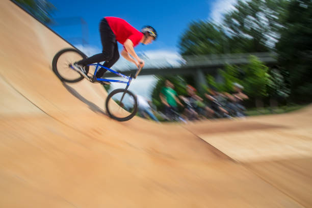 bmx всадника перепрыгивая на u рампы в скейтпарк - bmx cycling bicycle cycling backflipping стоковые фото и изображения