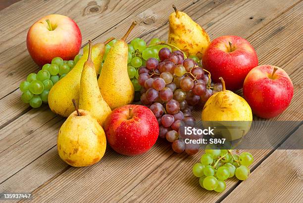 Manzanas Uvas Y Peras En Mesa De Madera Foto de stock y más banco de imágenes de Alimento - Alimento, Amarillo - Color, Color vibrante