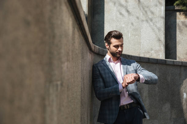 istock Handsome young businessman looking at watch. 1359374514