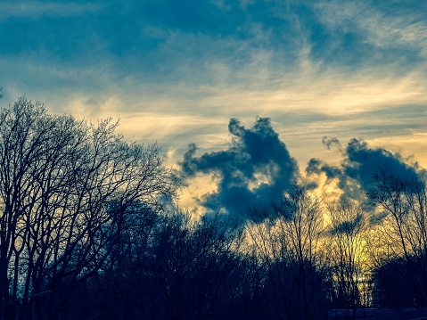 A dramatic sky with tree tops.