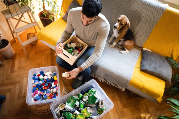 istock Responsible man, sort out caps and cans for recycling at his home 1359376005