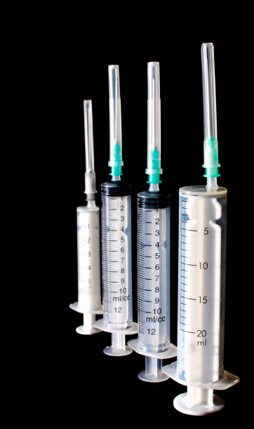 istock Medical syringes of different sizes on a dark background. 1359377039
