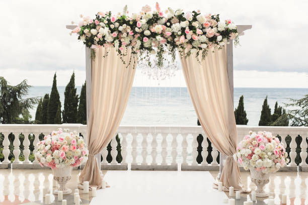 свадебная арка, украшенная цветами, стоит в роскошной зоне свадебной церемонии. - altar стоковые фото и изображения