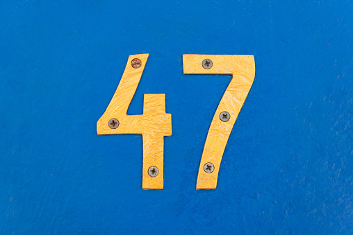 numbers forty seven on blue iron door colored inscription brightness four and seven