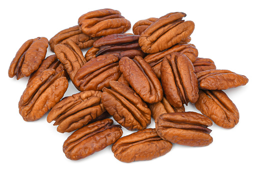 Pile Pecan nuts isolated on white background. Heap shelled Pecans nut closeup. Tasty raw organic food and healthy snack.