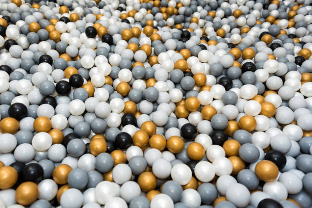 istock Many different color (white, gold, grey, black) plastic balls in ball pool at indoors playground 1359385481