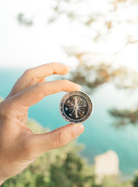 istock Man traveler holds a compass in his hand. 1359389952