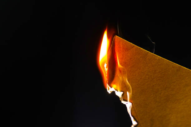 istock Burning piece of crumpled paper on black background 1359390877