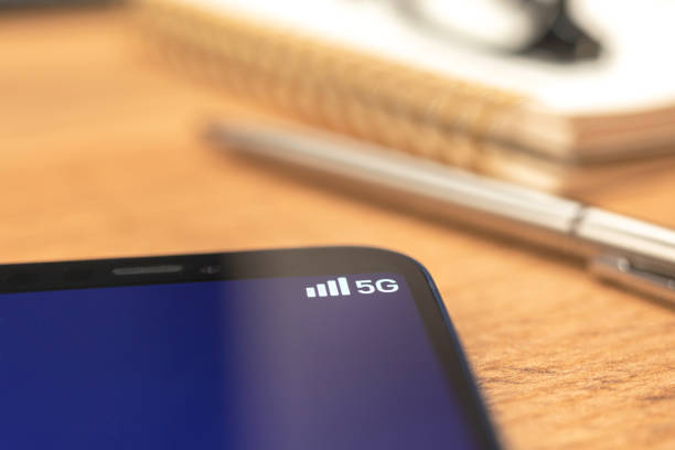 Mobile phone connected to 5G network wireless system. Business desktop background photo