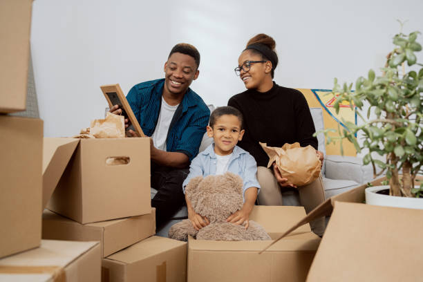istock Apartment cluttered with cardboard boxes after move parents son unpacking things while sitting on couch in living room married couple reminiscing about their youth while looking at picture in frame 1359392446