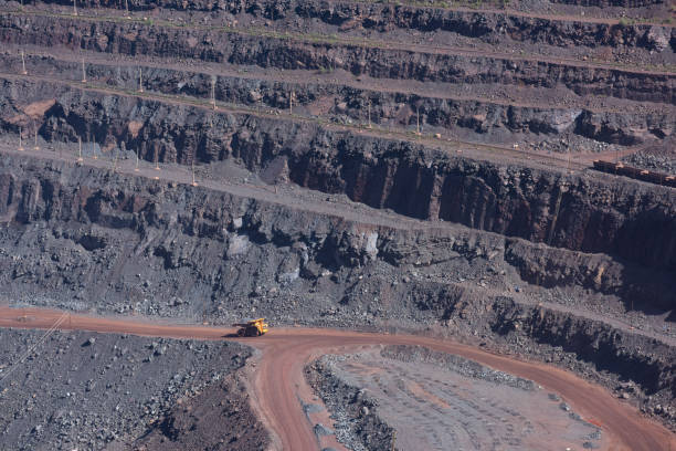 istock Open iron ore quarry with yellow quarry truck 1359394720