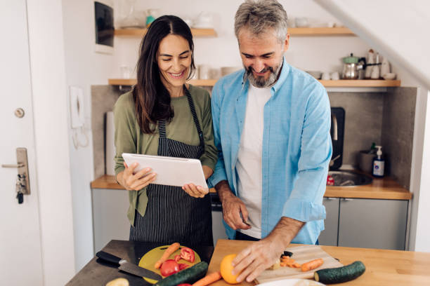 istock Mature couple using tablet while preparing their veggie meal to go 1359396563