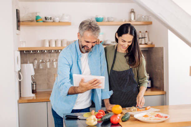 istock Mature couple using tablet and making a takeaway vegetarian meal 1359396585
