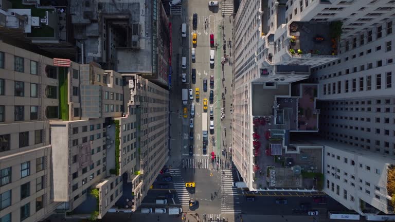 Aerial birds eye overhead top down panning view of cars moving on wide streets between high rise buildings in city. Manhattan, New York City, USA