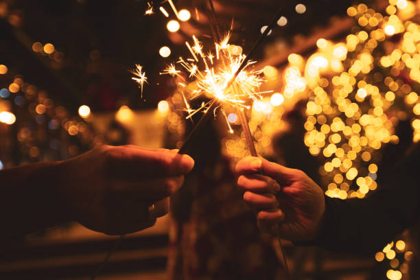 istock Two hands with sparklers on a Christmas or New Year's eve background 1359396738