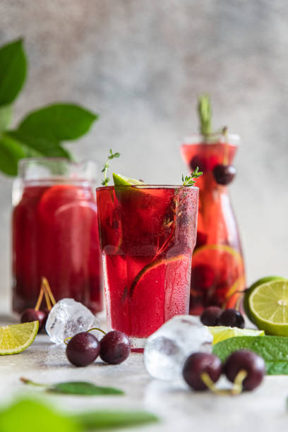 istock Cocktail or lemonade with cherries and lime, grey stone background. Mocktail. Cold summer drink. 1359403261