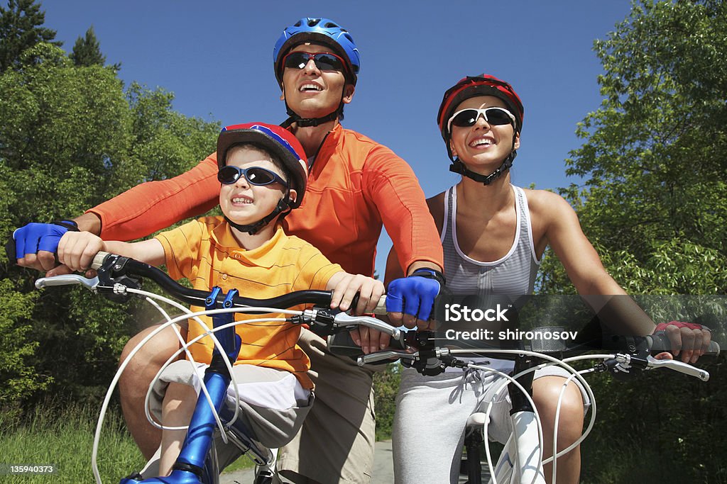 Recreation Portrait of happy family on bicycles in the park Activity Stock Photo