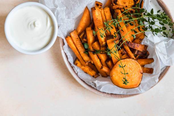 cunhas de batata doce caseira saudável com molho de molho de molho de creme e ervas no fundo de concreto. lanche saudável. - sweet potato french fries yam baked - fotografias e filmes do acervo