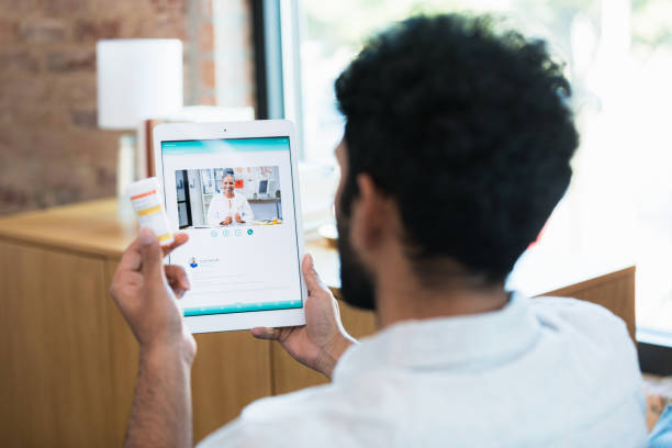 istock Unrecognizable man holds pill bottle during video consultation with doctor 1359410938