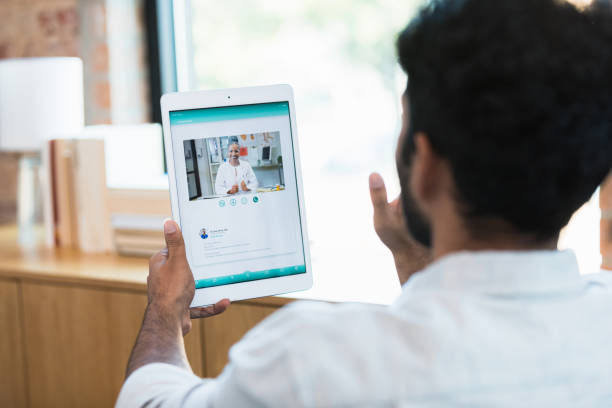 istock Unrecognizable man waves to doctor on video call 1359410939