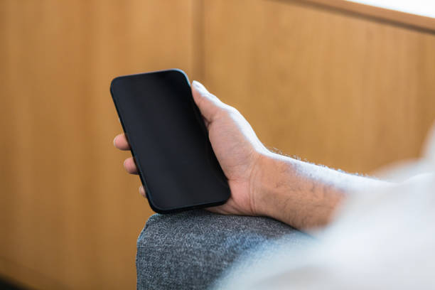 3D Render Black Mobile phones lined up side by side on black background. Communication Concept