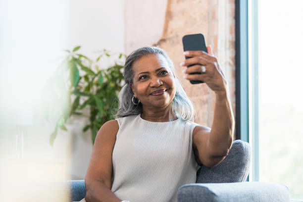 istock Woman holds phone up to take selfie 1359410962