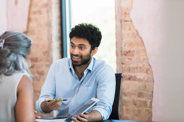 istock Mid adult man gestures while presenting to female boss 1359410973