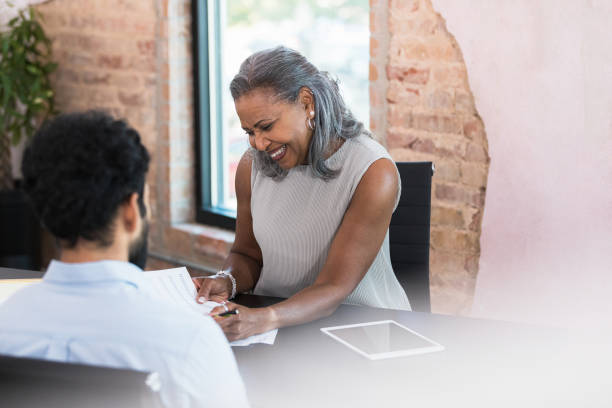 istock Female manager and employee discuss paperwork 1359410978