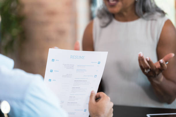 istock Focus on senior woman's resume during interview 1359410980