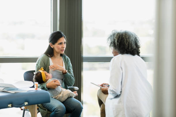 istock Mother gestures to baby while talking to pediatrician 1359412020