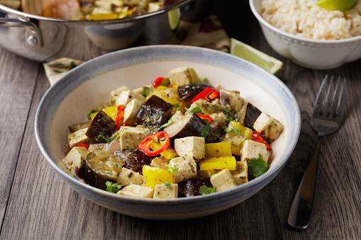 Homemade aubergine, tofu, and bell pepper Thai green curry serve with boiled brown rice