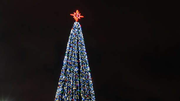 istock Lights of christmas tree blurred bokeh on dark background with copy space. Abstract festive background. 1359415676