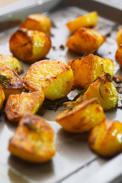 istock Roasted potatoes on the baking sheet with garlic and rosemary, selective focus 1359417012