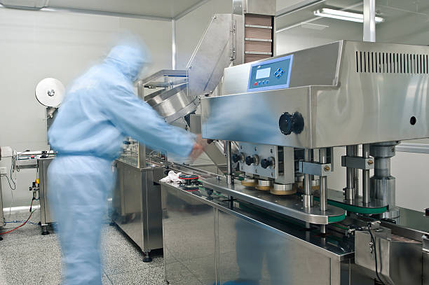 Pharmaceutical technicians at work in a lab Pharmaceutical technicians are working pharmaceutical manufacturing machine stock pictures, royalty-free photos & images