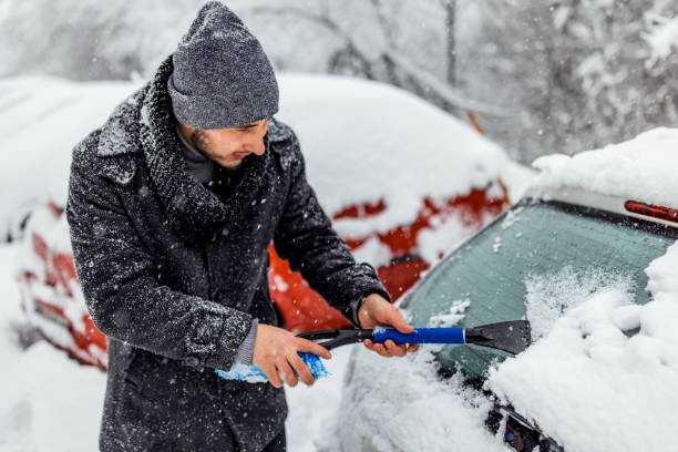 젊은 남자는 얼음에서 자동차 유리를 청소합니다. - snow car window ice scraper 뉴스 사진 이미지