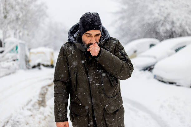 il ritratto dell'uomo maturo caucasico di bell'aspetto in stile casual si sta congelando nella fredda giornata invernale mentre si trova nel centro della città. - snow loneliness tree remote foto e immagini stock