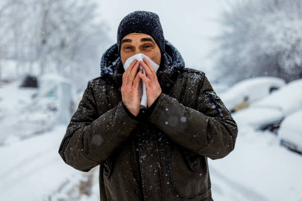 istock Man blowing his nose in the cold weather 1359419522