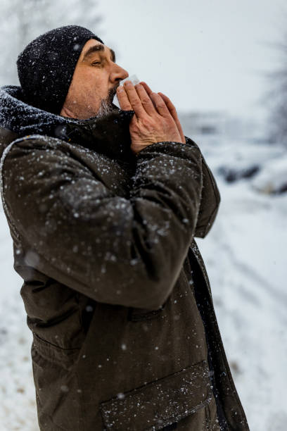 istock Man blowing his nose in the cold weather 1359419528