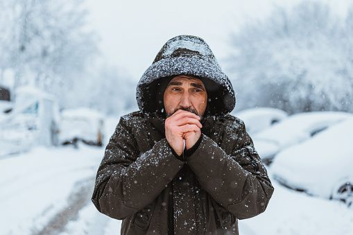 Retrato tomado del hombre maduro caucásico de buen aspecto en estilo casual se congela en el frío día de invierno mientras está de pie en el centro de la ciudad. photo