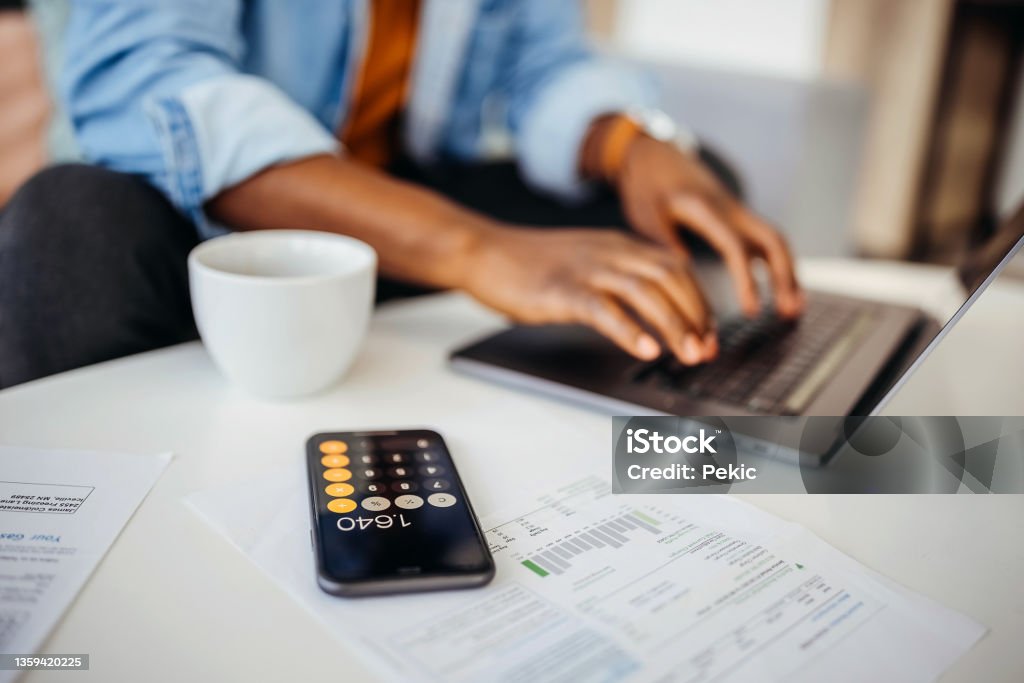 Close up of an unrecognisable man going over finances at home office Home Finances Stock Photo