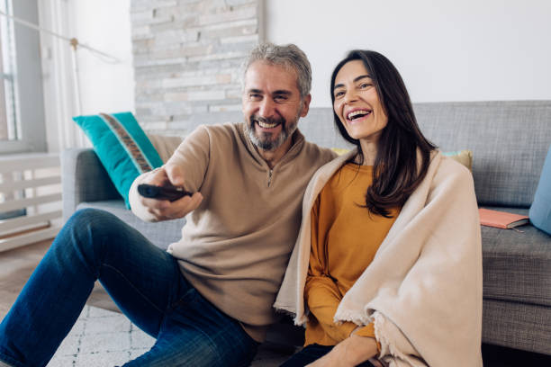 istock Mature couple watching TV at home 1359420403