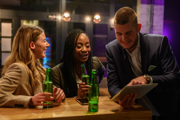 istock Cheerful colleagues drinking beer in the bar together after work 1359426634