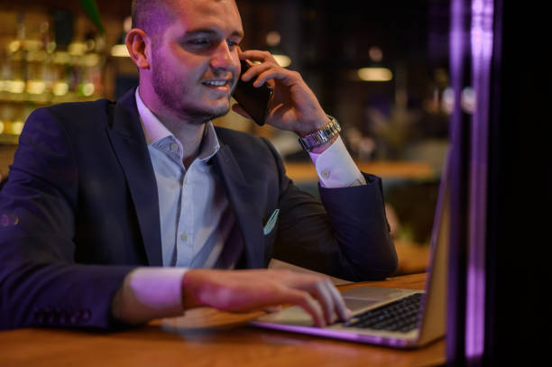 istock Businessman using smartphone and working on his laptop while drinking coffee in a cafe 1359426652
