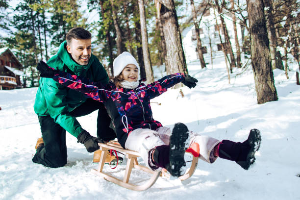 istock Happy girl and her dad sledding 1359427436