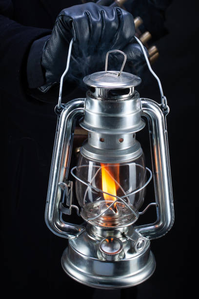 cold blast kerosene lantern in hand and gun - police crime gun gang member imagens e fotografias de stock