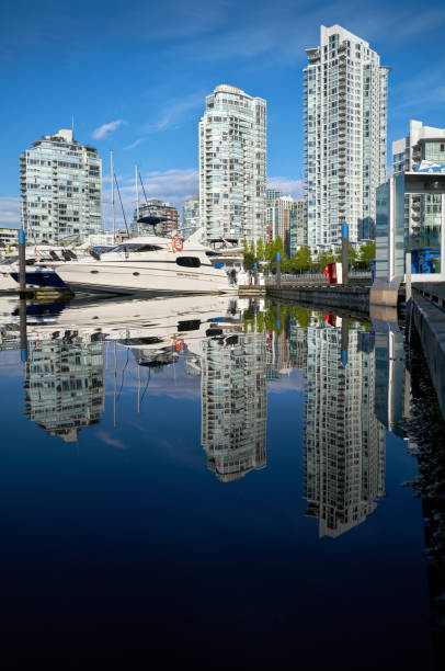 Vancouver harbor view with urban apartment buildings and bay boat at dusk in Canada.