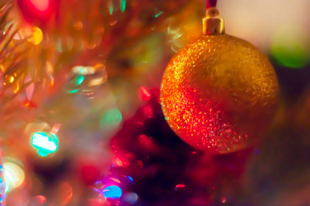 istock Blurry, defocus background with a Christmas tree and a yellow ball close-up 1359444069