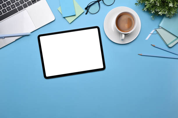 istock Top view digital tablet, coffee cup, sticky notes and laptop on blue background. 1359454855