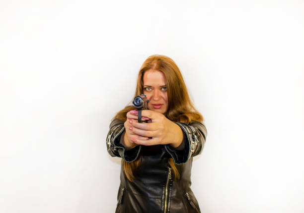 istock young beautiful woman with a gun 1359456574